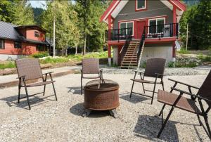 un grupo de sillas y una hoguera frente a una casa en Brand New 3BR Cabin w/Indoor Fireplace and Laundry, en Sunshine Valley