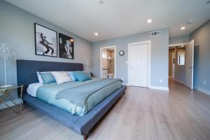 una camera con un grande letto con testiera blu di Glamorous 4 bedroom Townhome 10 min from Universal a Los Angeles