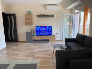 a living room with a couch and a flat screen tv at Hancho - Velingrad - Marvel Apartament in Velingrad +4 photos
