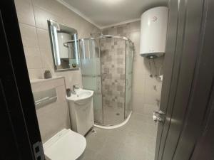 a bathroom with a shower and a toilet and a sink at Hancho - Velingrad - Marvel Apartament in Velingrad