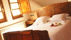 a bedroom with a large wooden bed with flowers on it at Hotel Mirador de Moriyón in Miravalles