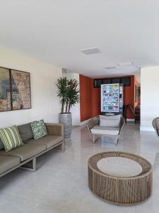 a living room with two couches and a table at Guarajuba Paraiso dos Coqueiros B02 in Camaçari