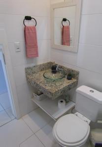 y baño con lavabo y aseo. en Recanto aconchegante no Campeche Apart 05 - 50m da praia -, en Florianópolis