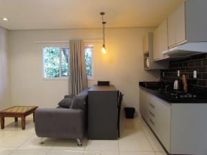 Il comprend un salon avec un canapé et une cuisine. dans l'établissement Recanto aconchegante no Campeche Apart 05 - 50m da praia -, à Florianópolis