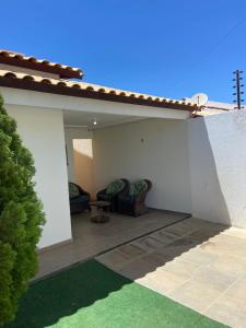 een patio met 2 stoelen en een tafel bij Linda Casa com piscina e totalmente climatizada Airbn b in Petrolina