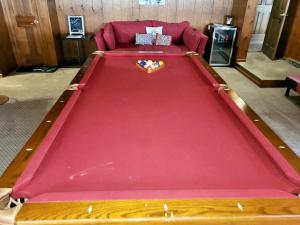 einen großen roten Billardtisch im Wohnzimmer in der Unterkunft Sai Rakshit Villa on Maurice River in Millville
