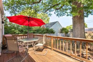 einen Tisch und Stühle auf einer Terrasse mit einem roten Regenschirm in der Unterkunft Private, Tranquil Living in Historic RVA Awaits! in Richmond