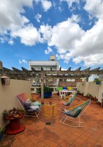 a patio with chairs and tables on a roof at Casa Reina Palermo Queens in Buenos Aires