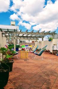 eine Terrasse mit Stühlen und einem Tisch auf dem Dach in der Unterkunft Casa Reina Palermo Queens in Buenos Aires