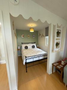 um quarto com uma cama com tecto de nuvens em Pwllglas Bach - Spacious Cabin em Machynlleth