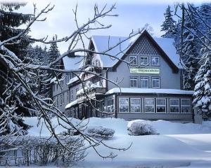 a large building in the snow with snow covered trees at Waldhotel Friedrichroda in Friedrichroda