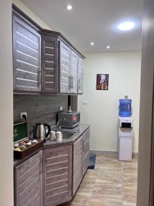 a kitchen with wooden cabinets and a counter top at Z3 Hostel in Wadi Musa