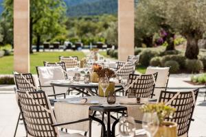 a group of tables and chairs on a patio at Castell Son Claret - The Leading Hotels of the World in Capdellá