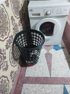 a washing machine sitting next to a laundry basket at Appartement Meublé Avec 3 Façades Dans Une Zone Calme in Tangier