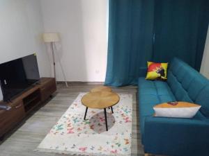 salon z niebieską kanapą i stołem w obiekcie Residence Eliz w mieście Kabrousse