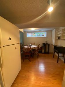 a kitchen with a refrigerator and a table with chairs at Spacious Guest house -walkout Basement- 4 guests! -dedicated workspace-No Pet! No Cooking! No Smoking! No Party! in Ottawa