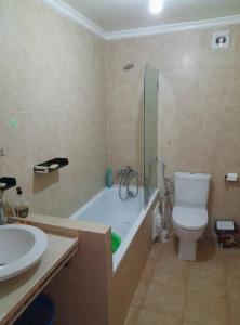 een badkamer met een toilet, een bad en een wastafel bij Appartement Al cudia smir in Fnidek