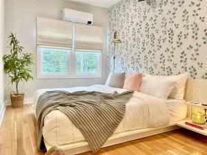 1 dormitorio con cama blanca y papel pintado con motivos florales en Cabin Vibes Condo in North Capitol Hill, en Seattle