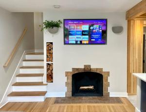 a living room with a fireplace and a tv on the wall at Cabin Vibes Condo in North Capitol Hill in Seattle
