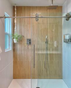 a shower with a glass door in a bathroom at Cabin Vibes Condo in North Capitol Hill in Seattle