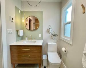 a bathroom with a sink and a toilet and a mirror at Cabin Vibes Condo in North Capitol Hill in Seattle