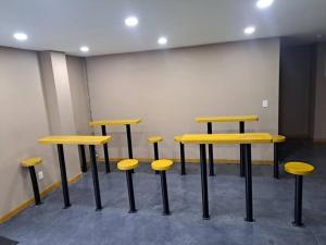 a group of yellow tables and stools in a room at lugar para descansar ²⁰⁹ in Fortín de las Flores