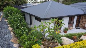 a small house with a black roof and some plants at 'Stay in Carrara' A private guest suite not a share house in Gold Coast