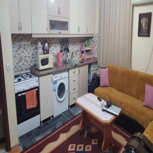 a living room with a couch and a kitchen at BE MY GUEST - Homestay ApartmentS Guest HouseS Sleeping Rooms in Antalya