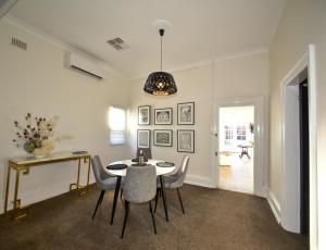 a dining room with a table and chairs at Macleay Cottage with plunge pool and local arts in Dubbo