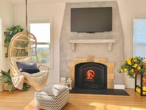 a living room with a fireplace with a chair and a television at Modern Amenities & Chic Design in Heart of Seattle in Seattle