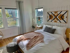 um quarto com uma grande cama branca num quarto com janelas em Modern Amenities & Chic Design in Heart of Seattle em Seattle