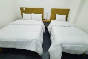 2 camas en una habitación pequeña con sábanas blancas en El lugar perfecto para descansar.²⁰⁸, en Fortín de las Flores