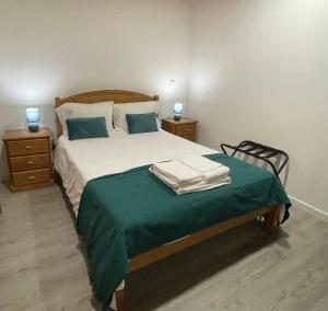 um quarto com uma cama grande e um cobertor verde em Casa do Forno D`Aldeia em Mouços