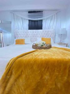 a bedroom with a large bed with a yellow blanket at AM.AIRBNB in Santo Domingo