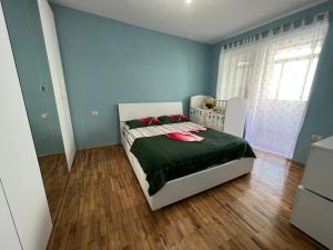Kukes Apartment Hotel في Kukës: غرفة نوم مع سرير مع لحاف أخضر
