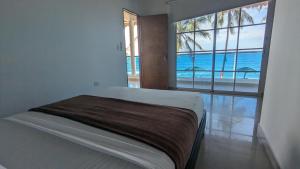 a bedroom with a bed with a view of the ocean at Beach Life Palomino - Beach Club & Party Hostel in Palomino