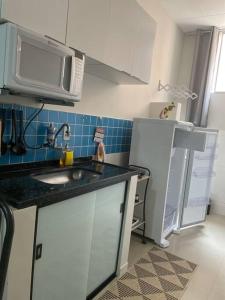 a small kitchen with a sink and a refrigerator at Apartamento encantador 6 in Montes Claros