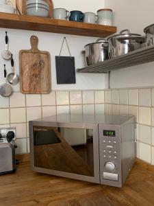 a microwave oven sitting on the floor in a kitchen at Abbey and Clock Tower view in St. Albans