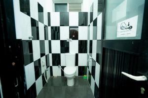 a bathroom with a toilet and black and white tiles at East Gate 8-9 Batticaloa in Batticaloa