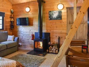 a living room with a fireplace in a log cabin at Lekido in Hernehill