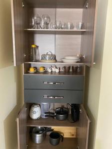 a kitchen with a shelf with dishes and utensils at Apartamento Encantador B in Montes Claros