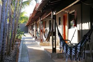 a hammock outside of a building with palm trees at Pousada Divino Canto in Olímpia