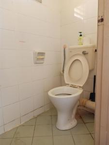 a bathroom with a toilet with the lid up at Low Budget Economy SingleBed Bedroom in Aman Puri, Kepong in Kuala Lumpur