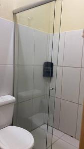 a bathroom with a glass shower with a toilet at Apartamento encantador 04 in Montes Claros