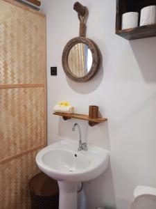 a bathroom with a sink and a mirror on the wall at Terei-Here Bungalow Airport in Avae
