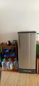 a silver refrigerator sitting on the floor next to a shelf at Low Budget Economy SingleBed Bedroom in Aman Puri, Kepong in Kuala Lumpur