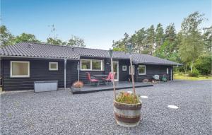 a black tiny house with a patio and a table at Awesome Home In Ebeltoft With Sauna in Ebeltoft