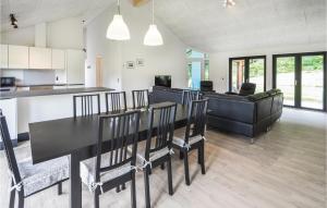 エーベルトフトにあるAmazing Home In Ebeltoft With Indoor Swimming Poolのキッチン、リビングルーム(黒いテーブル、椅子付)