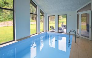 エーベルトフトにあるAmazing Home In Ebeltoft With Indoor Swimming Poolの家屋内の窓付きスイミングプール