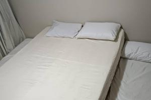 アハイアウ・ド・カボにあるPrainha com Requinte, Apartamento em Arraialの枕が2つ置かれた白いベッド